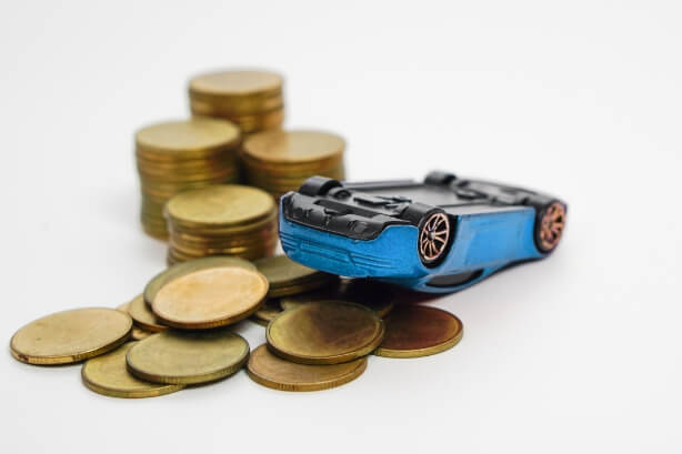 Spielzeugauto und aufgetürmte Münzen